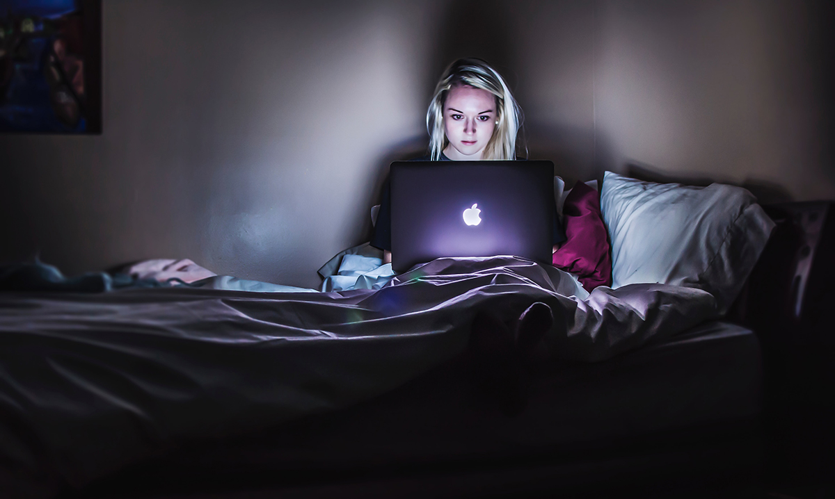 Girl watching videos on a laptop in bed