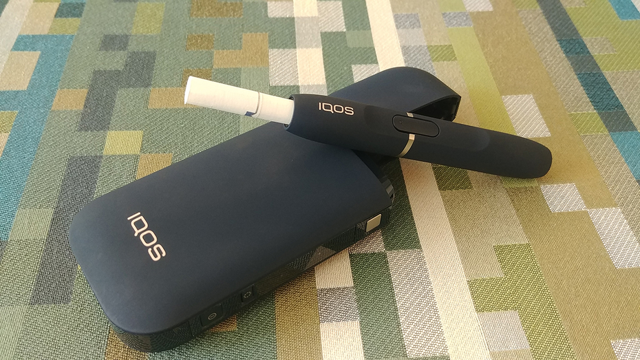 IQOS on a green patterned background