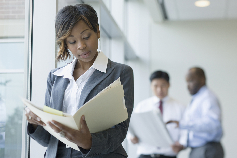 Woman walking and looking at papers