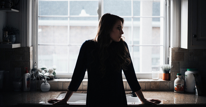 Concerned young woman in a kitchen