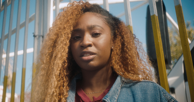 Young Black Woman Reads Tobacco Industry Quote