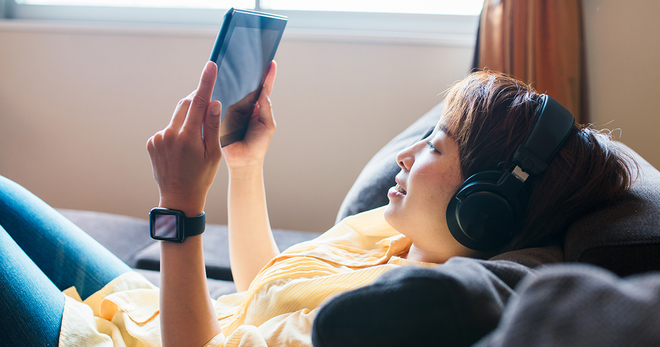 Girl on the couch watching shows on a tablet