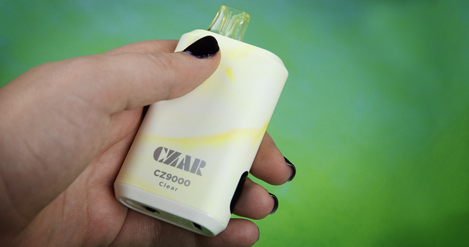 A hand holding a clear vape