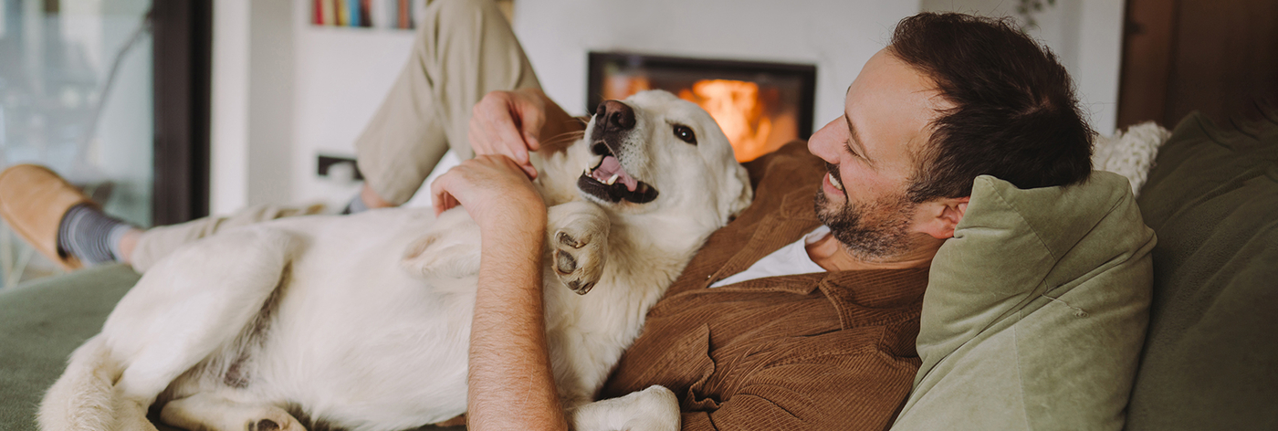 A man on the couch with his dog